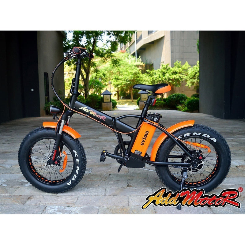 AddMotor 500W Motan M-150 Folding Fat Tire bicycle parked in front of business
